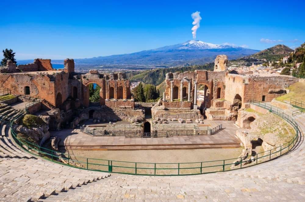 Veduta del teatro di Taormina e dell’Etna, tappa imperdibile di un tour in pullman privato in Sicilia.